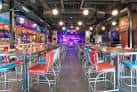Interior del Tin Roof con barra y zona de eventos iluminada