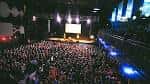 Interior del auditorio durante un evento con público y escenario iluminado