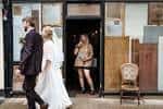 Pareja de novios caminando frente a la entrada del centro durante una boda