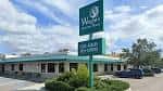 Fachada exterior de Wright's Gourmet House con letrero verde y estacionamiento