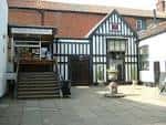 Fachada exterior del Maddermarket Theatre con estilo Tudor y patio empedrado