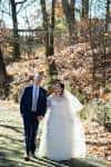 Pareja de novios caminando por un sendero boscoso durante su boda