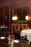Sala privada elegante con decoración en tonos oscuros y mesa servida