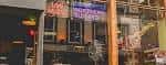 Fachada nocturna del Northern Guitars con letreros luminosos de 'Live Music'
