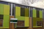 Fachada exterior del Triangle Children's & Community Centre con paneles verdes y marrones