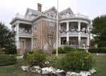 Vista exterior de la casa Woodward con arquitectura victoriana y porche curvo