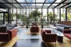 Lounge interior con diseño contemporáneo, grandes ventanales y sofás de colores cálidos