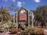 Señal de entrada del ZooTampa at Lowry Park con elefante y vegetación tropical