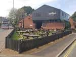 Vista exterior del Brewery Tap en Norwich con jardín y mesas al aire libre