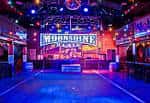 Interior del Moonshine Flats con escenario y luces de discoteca