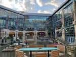Vista del atrio interior del Rivercenter Mall con escaleras y tiendas