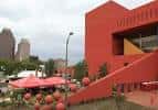 Fachada roja vibrante de la biblioteca con elementos urbanos y espacio al aire libre