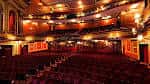 Interior del auditorio del Phoenix Theatre con butacas rojas y balcones ornamentados