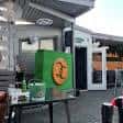 Exterior del establecimiento con decoración verde y logo visible
