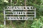 Señal de entrada del Meanwood Valley Urban Farm rodeada de vegetación