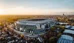 Vista aérea del Allianz Stadium al atardecer, mostrando su arquitectura moderna y entorno urbano