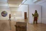 Interior de la galería con obras de arte contemporáneo y visitantes