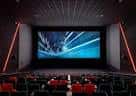 Interior de la sala de cine con butacas rojas y pantalla grande