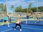 Jugadores practicando pickleball en las canchas azules del parque