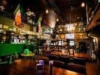 Interior del bar con decoración temática irlandesa, barra principal y ambiente acogedor para eventos