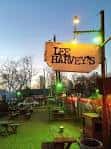 Entrada nocturna de Lee Harvey's con letrero principal y ambiente al aire libre