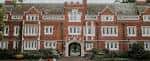 Fachada principal del edificio histórico de Reed College con arquitectura gótica y entrada arqueada