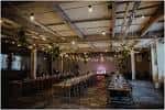 Interior del Trafalgar Warehouse decorado para una boda con mesas largas y luces cálidas