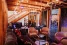 Interior acogedor del Fallser Club con escalera de madera y zona de lounge