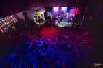 Escenario iluminado con banda en vivo durante un evento nocturno