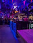 Interior del bar Billy Bootleggers con barra iluminada y ambiente festivo