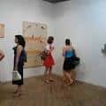 Visitantes observando obras de arte en una exposición dentro del espacio cultural