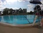 Vista panorámica de la piscina John B. Kelly con tumbona y sombrilla en primer plano