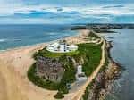 Vista aérea del faro Nobbys en Newcastle con el rompeolas y la costa
