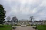 Vista general de los invernaderos principales del jardín botánico con césped y bancos