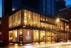 Fachada iluminada del Grand Central Hotel Belfast al atardecer, mostrando su diseño arquitectónico contemporáneo