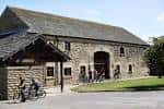 Vista exterior del Herd Farm Activity Centre con visitantes en bicicletas