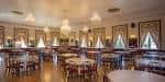 Salón de eventos del Centro Asturiano con mesas redondas y cortinas decorativas