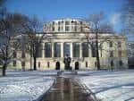 Vista exterior de la Thompson Library en invierno con fachada neoclásica y nieve