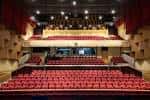 Interior del auditorio con butacas rojas y escenario