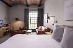 Habitación moderna del Titanic Hotel con cama doble, escritorio y ventana grande