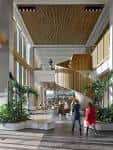 Interior moderno del vestíbulo con escalera central y plantas decorativas