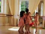 Niñas en clase de ballet con tutús rosados en un estudio luminoso