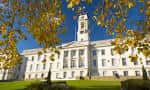 Fachada clásica del edificio principal de la Universidad de Nottingham rodeado de árboles otoñales