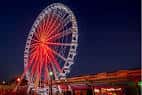 El St. Louis Wheel brillando en rojo y blanco al atardecer