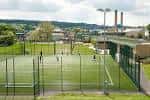 Vista exterior de las pistas deportivas del U-Mix Centre con césped artificial y vallas perimetrales