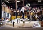 Skateboarder realizando un truco en rampa durante evento con público