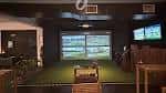 Interior del lounge con campo de golf indoor y pantallas