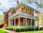 Vista exterior de la casa histórica del Presidente Benjamin Harrison con porche y bandera estadounidense