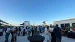 Evento al aire libre en la terraza con invitados y cielo despejado