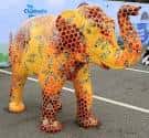 Elefante escultórico colorido con diseño de panales en espacio público